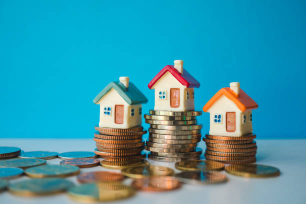 Miniature colorful house with stack coins Miniature colorful house with stack coins on blue background using as property and financial concept money house stock pictures, royalty-free photos & images