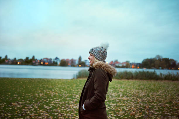 Cropped shot of an attractive young woman smiling while standing in park in late autumn