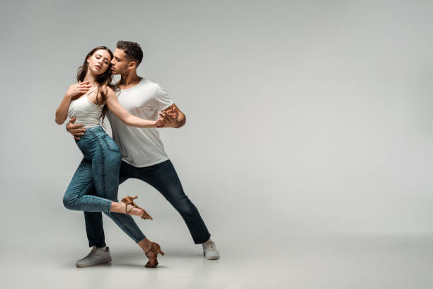 istock dancers in denim jeans dancing bachata on grey background 1195081300