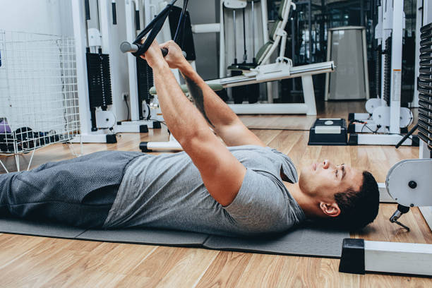 istock Kinesitherapy, a mixed race man is training in a wellness center, on special simulators 1195081450