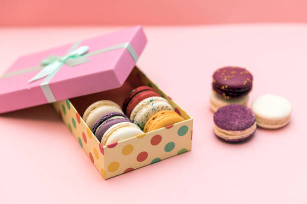 istock Multi-colored macaroon cakes on a pink pastel background in the gift box 1195082251
