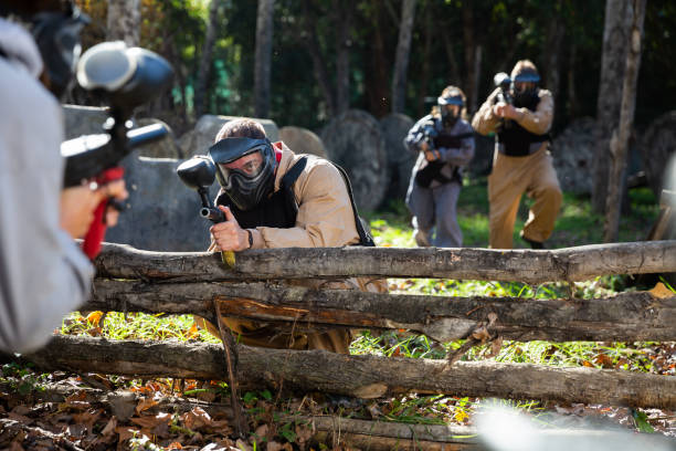 istock Paintball players aiming outdoors 1195083589