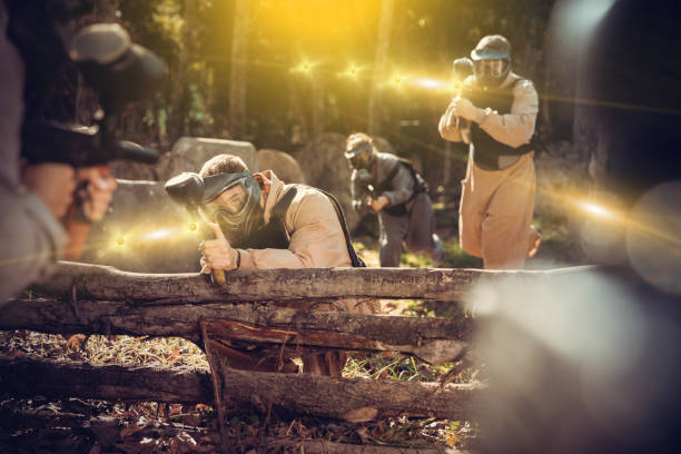 istock Paintball players shooting with guns 1195083591