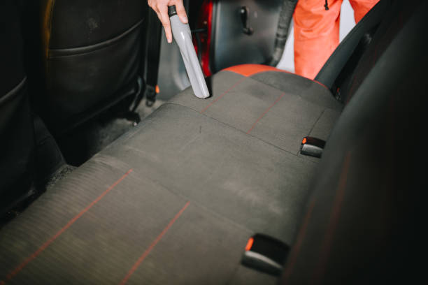 istock Man cleans car interior with vacuum cleaner 1195084134