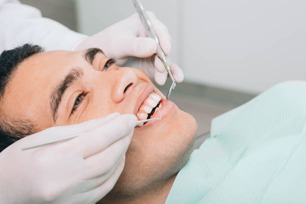 istock African american man check up teeth with dental equipment 1195084231