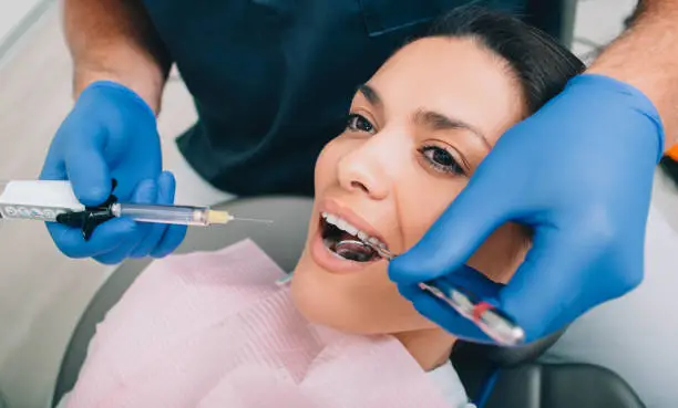Woman getting procedure teeth anesthesia by her dentist. Teeth treatment without pain