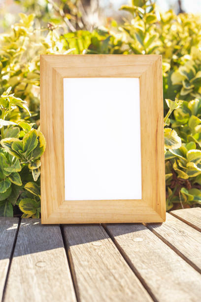 istock Wooden photo frame in front of bush 1195084664