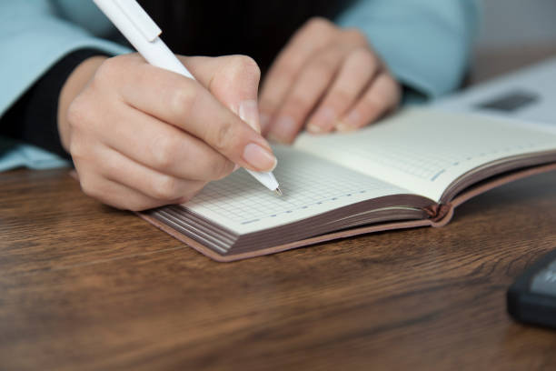 istock woman hand pen with notepad 1195085910
