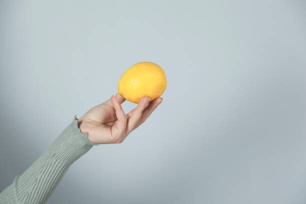 istock woman hand holding lemon 1195085963