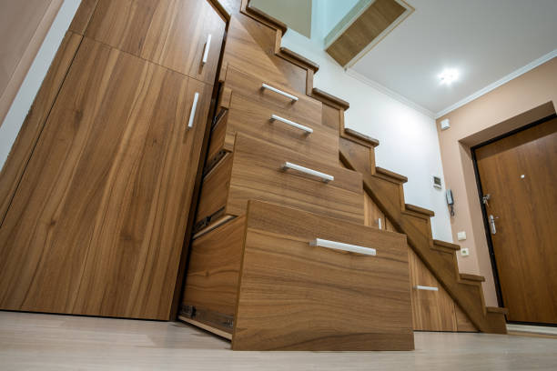 istock Modern architecture interior with luxury hallway with glossy wooden stairs in multi-storey house. Custom built pullout cabinets on glides in slots under stairs. Use of space for storage. 1195090568