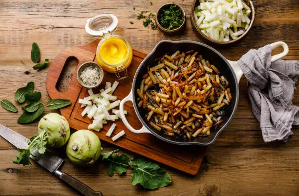 Fried Kohlrabi with Ghee and Sage on wooden table background