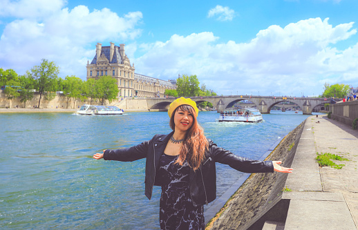 Asain woman enjoy her vacation in Paris with Pont neuf on the back, Paris, France.