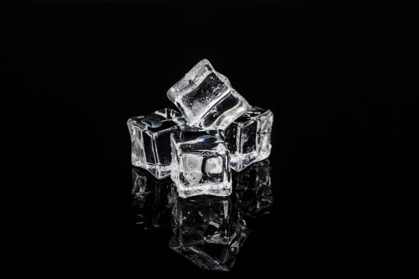 istock Ice cubes on a black reflective glass surface. Ice cubes on black glass. 1195104116