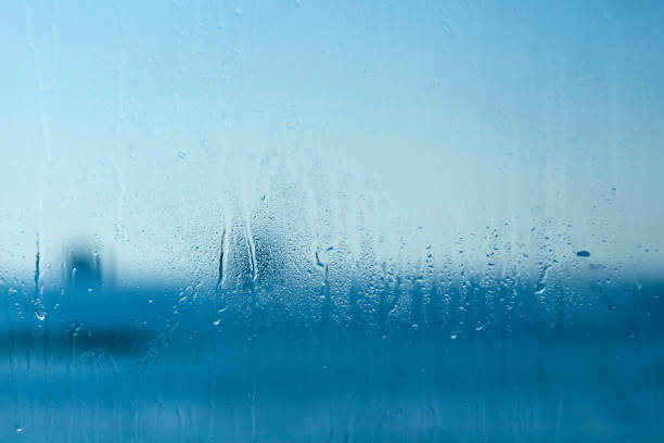 istock Blue window glass with drops and blurs 1195112620