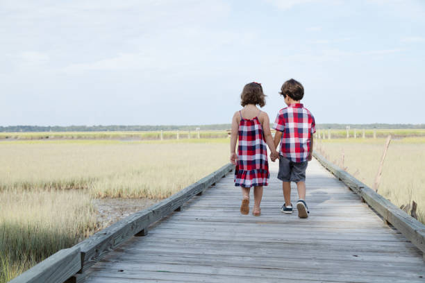 istock Children Holding Hands and Walking Outdoors 1195113450