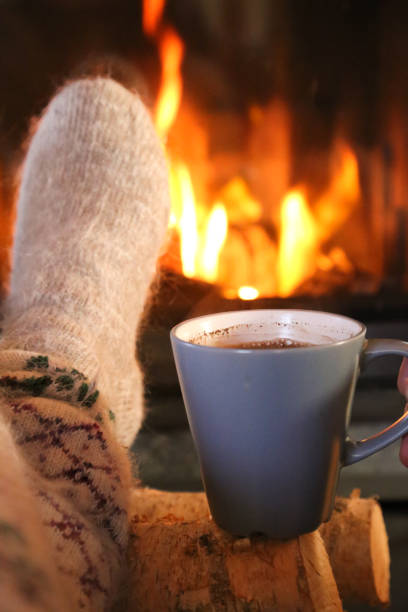 istock Feet in wool socks warming at the fireplace 1195114323