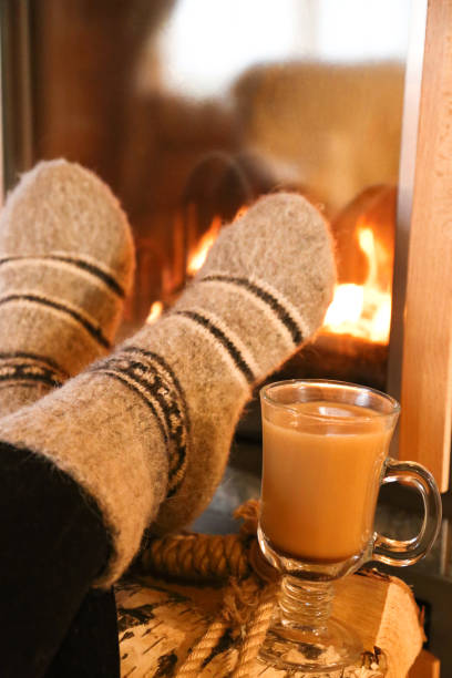 istock Feet in wool socks warming at the fireplace 1195114435