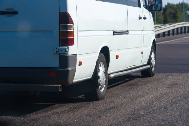istock Side view of white passenger bus on the sunny road. 1195117819
