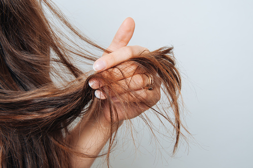 Chica sosteniendo su cabello en su mano. Concepto de cuidado del cabello. Champú. Se necesita corte de pelo. photo