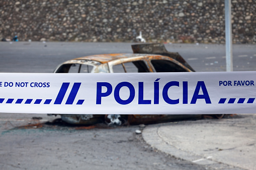 Lisbon, Portugal - June 23 2017: Car burnt by a pyromaniac with a police tape with written in it in Portuguese \