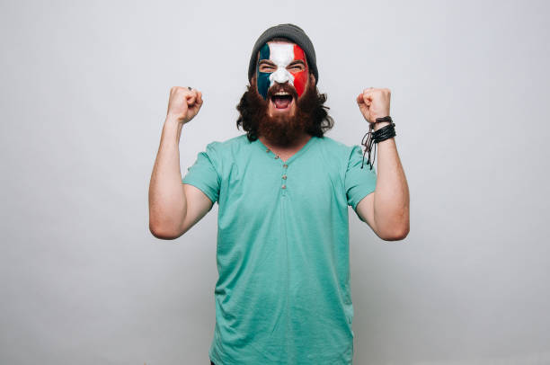 Bearded man screaming with face paintend France flag