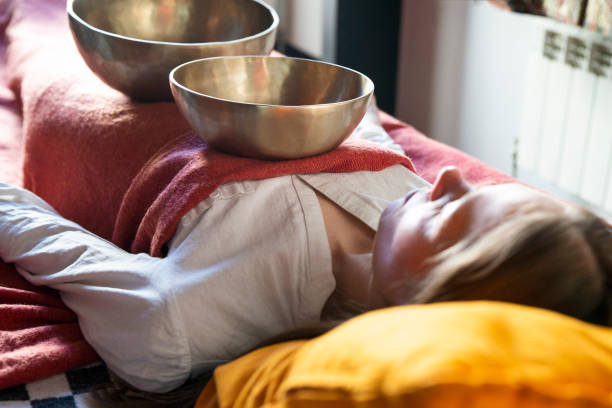 Tibetan singing bowls in sound therapy in spa center over a woman body Tibetan singing bowl in sound therapy gong stock pictures, royalty-free photos & images