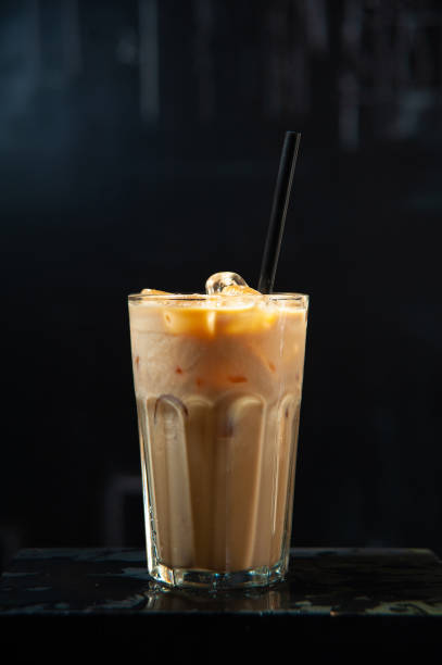 istock Frappe glass or iced latte on dark black background with ice cubes. 1195121109