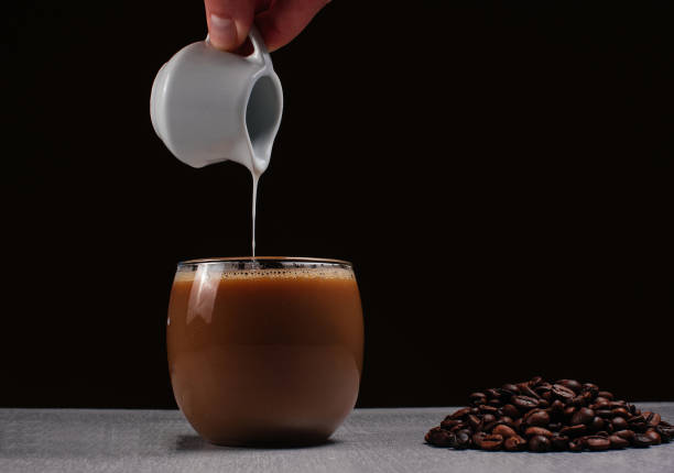 istock milk pouring in coffee 1195122825