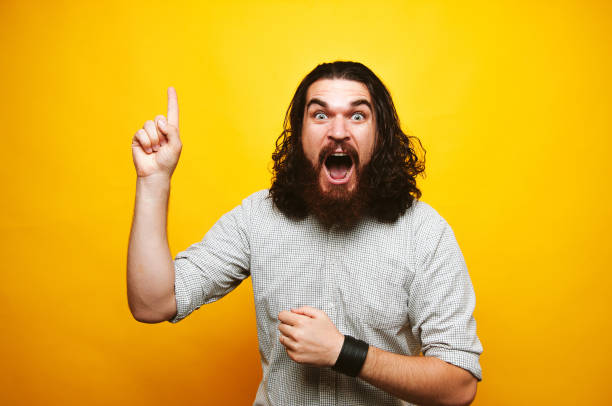 istock Amazed bearded man pointing up over yellow background 1195123468