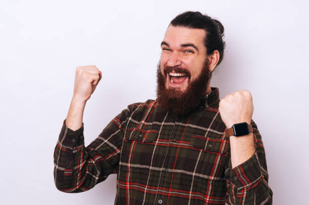 istock Young happy bearded man celebrating success over white background 1195125223