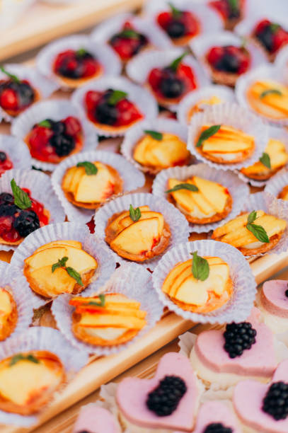 istock Delicious raspberry, peaches mini tarts (tartlets) with whipped cream on dark background 1195125277