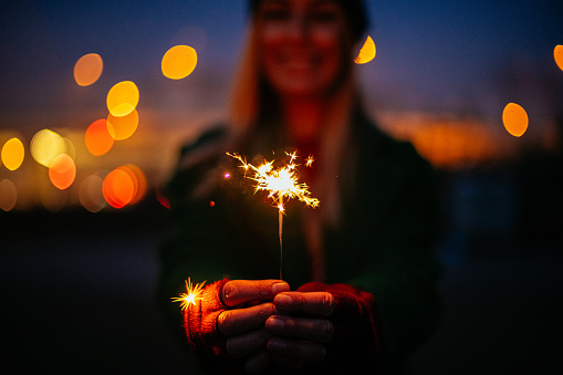 Young Woman Holding Sparkler at Christmas