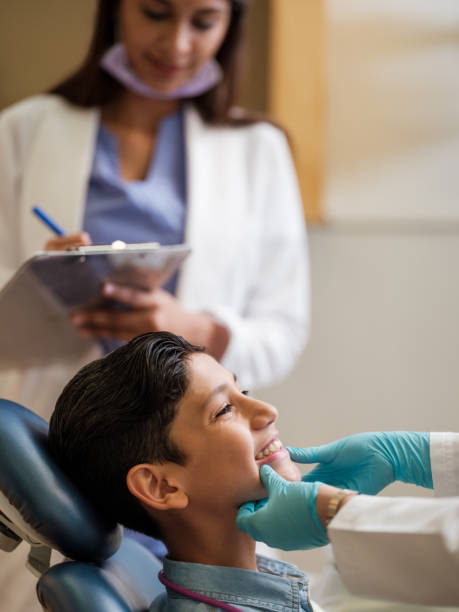 istock Latin boy showing teeth during dentist's appointment 1195128106