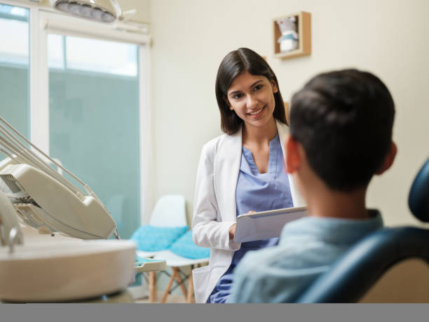 istock Latin female assistant looking at patient and taking notes 1195129191