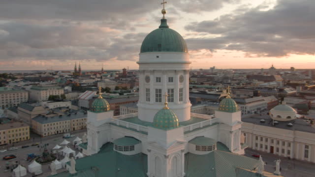 Circling drone shot of Helsinki Cathedral with beautiful cloud sky at sunset