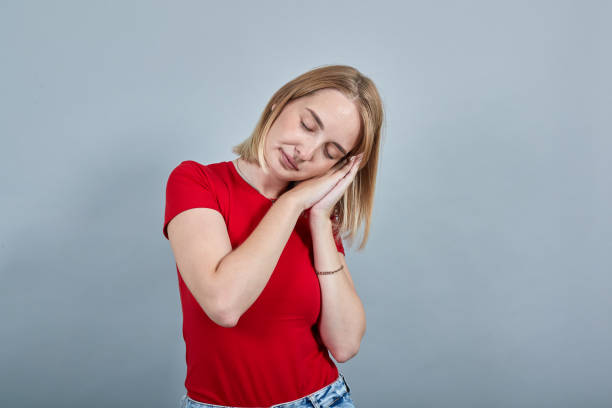 istock Pretty woman in red shirt posing sleeping with folded hands under cheek 1195148092