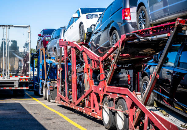 big rig samochód wozidła półciężarówka z załadowanymi samochodami na naczepie stojących na parkingu przystanku ciężarówki obok innego półciężarówki - truck semi truck car transporter vehicle trailer zdjęcia i obrazy z banku zdjęć