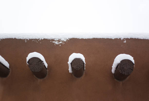 Santa Fe, NM: Old Adobe House Exterior Detail (Vigas/Beams) in Snowstorm. Copy space available.
