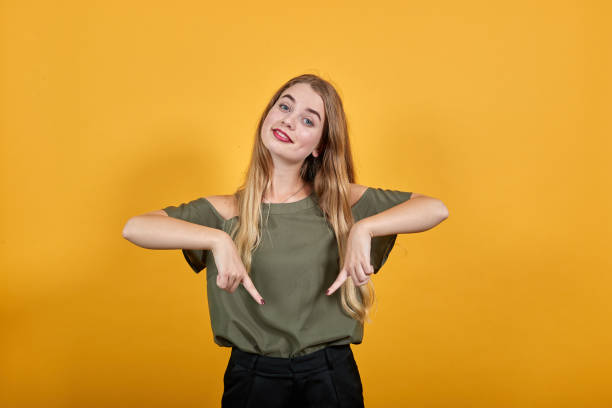 istock Beautiful person pointing down with fingers showing advertisement, surprised 1195157334