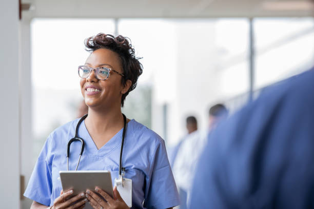 hermosa enfermera sonríe mientras sostiene la tableta digital - computer medical student hospital nurse fotografías e imágenes de stock