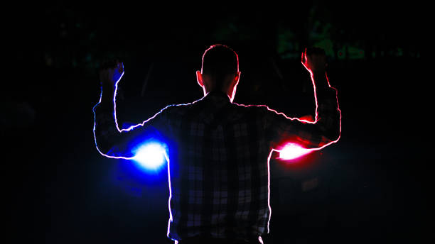 silhouette of  a male  criminal suspect with hands up during night pursuit in front of the police car headlights - cought imagens e fotografias de stock