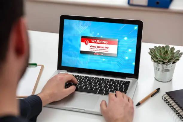 Photo of Virus detected warning text on a laptop screen