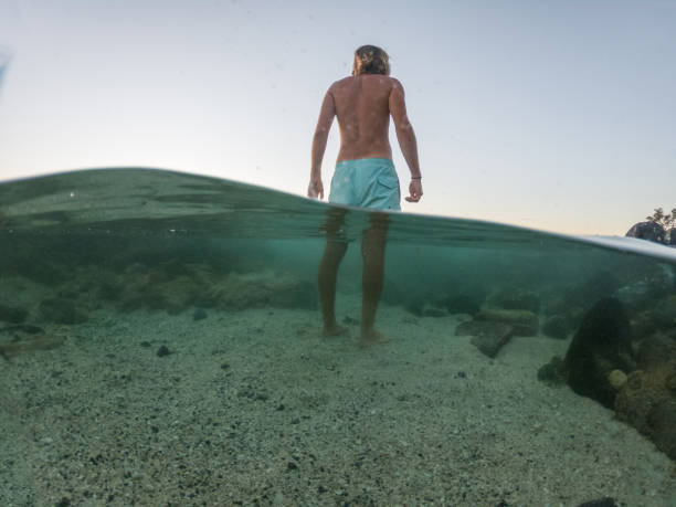 istock Underwater shot of man standing on beach, day dreaming 1195167263