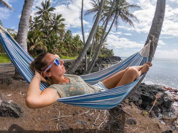 istock Girl relaxing on hammock at sunset by the beach 1195168063