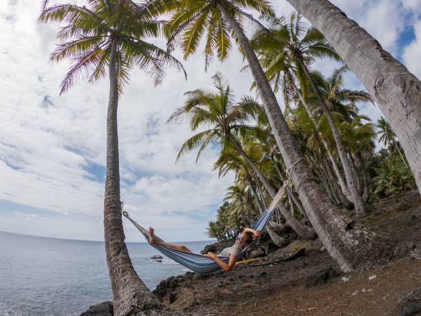 istock Girl relaxing on hammock at sunset by the beach 1195168064