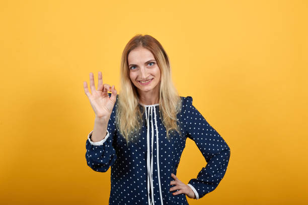 istock Smiling young woman looking directly, doing okay gesture 1195169835
