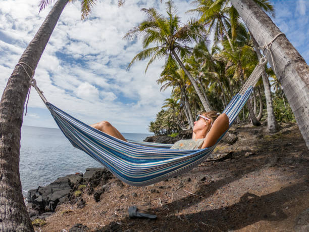 istock Girl relaxing on hammock at sunset by the beach 1195169852