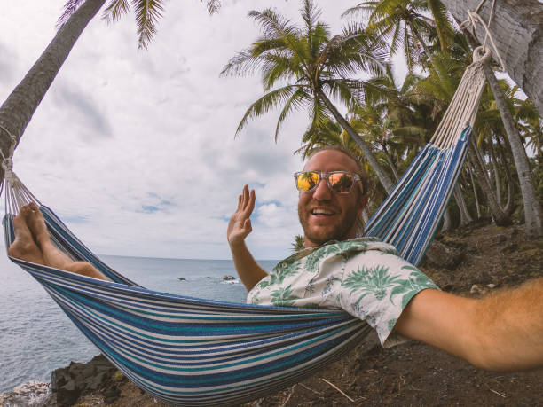 ung man på hängmattan tar en selfie, strandsemestrar - kustlinje videor bildbanksfoton och bilder