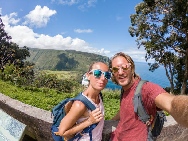 happy couple taking selfie picture while hiking in hawaii - hamakua coast imagens e fotografias de stock