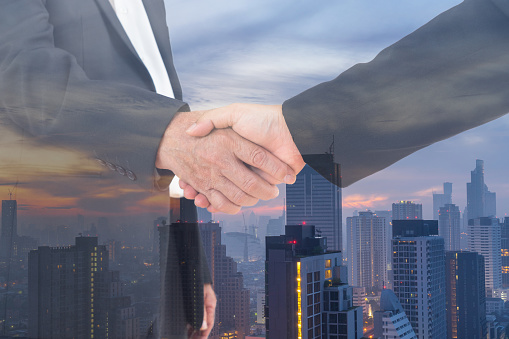 scenic of businessman shaking hand with cityscape background for commitment concept